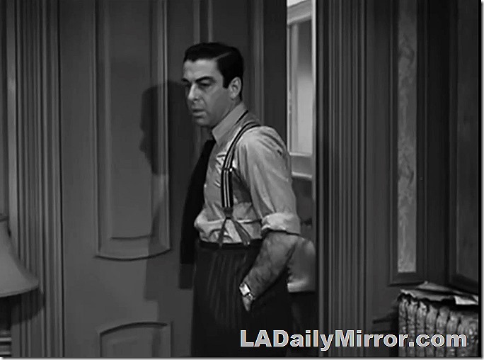 Dec. 21, 2021, Mystery Photo, a man in suspenders, shirt sleeves rolled up, in front of a door 