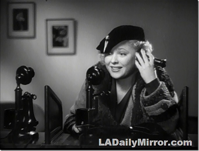 Blonde woman in hat and coat on French candlestick telephone