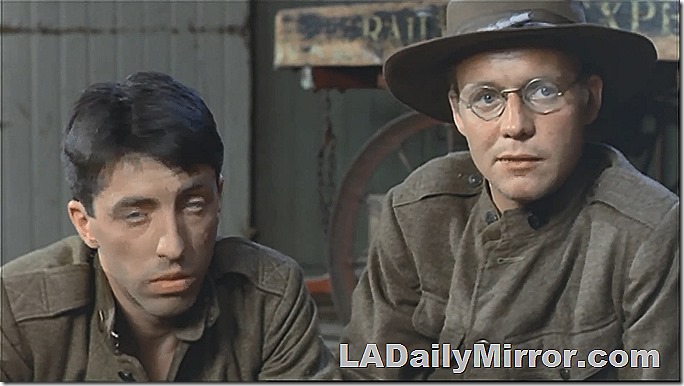 Soldiers in uniform. One wears a campaign hat and glasses. 