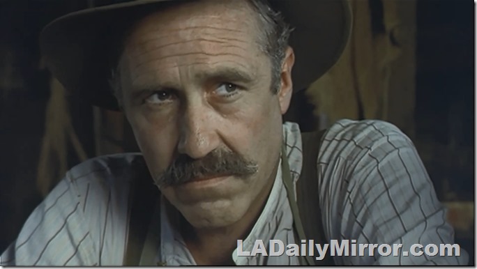 Man in a hat, with a mustache and suspenders (the man, not the hat)