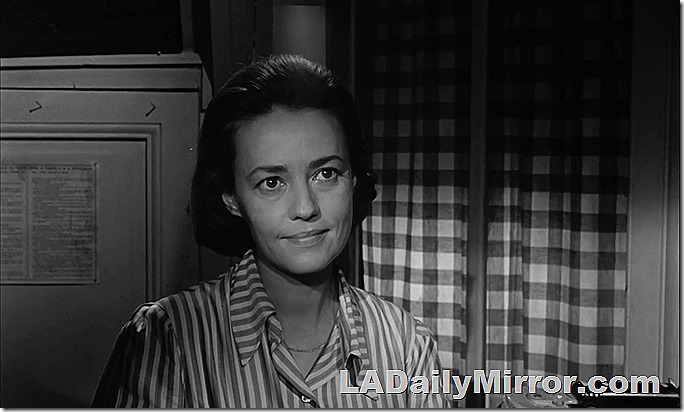 Woman in a striped blouse against a checkerboard curtain