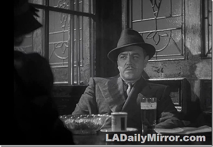 Man in hat and coat with wide lapels.  