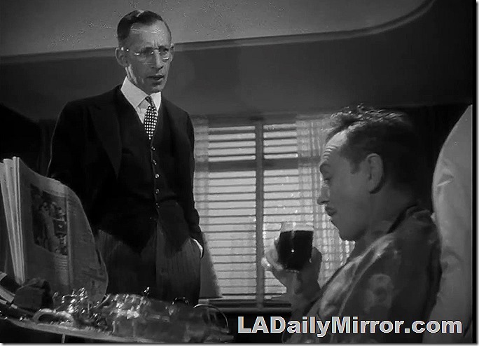 Mystery fellow in coat and vest, glasses. Talking to Wednesday's mystery fellow. 