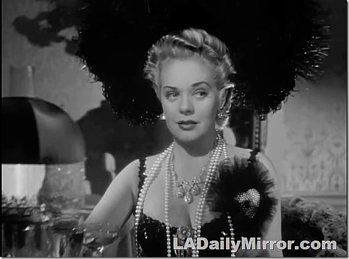 Theatrically dressed woman in a strapless gown covered with sequins and a huge hat. Many strands of pearls. Theatrically dressed woman in a strapless gown covered with sequins and a huge hat. Many strands of pearls.