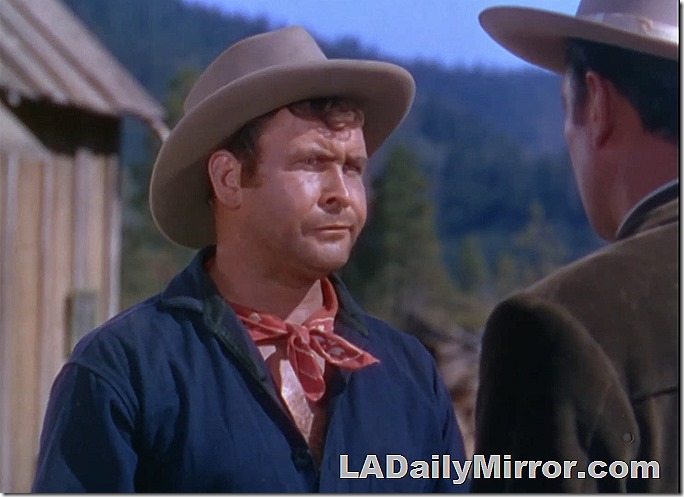 Man in blue shirt, red neckerchief and hat. He does not approve of such goings-on. 