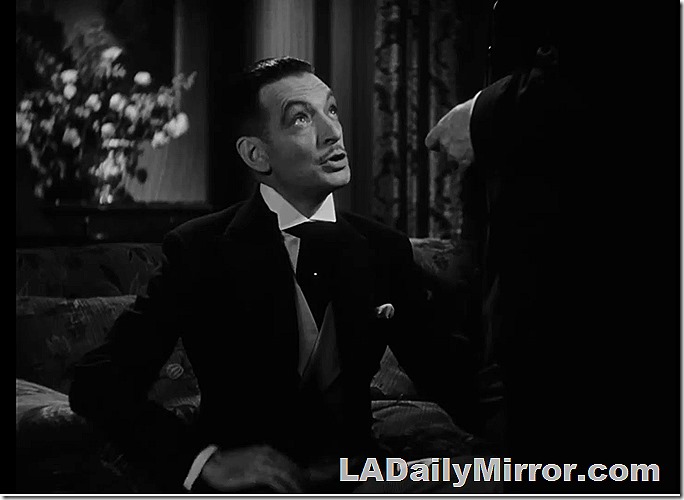 Man with pomaded hair, slight mustache, in wing collar. 