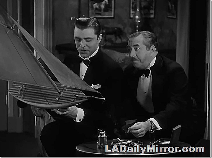 Man in tuxedo, smoking cigarette is looking out of frame (which has been cropped)