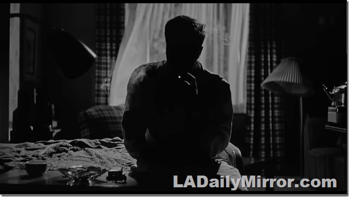 A man in silhouette, smoking a cigarette 