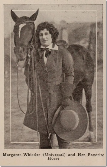 Margaret Whistler stands next to a horse. She is wearing riding clothes and holding a large hat. 
