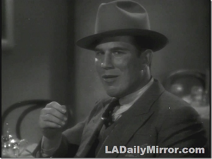 Man in suit with wide lapels, vest and hat. 