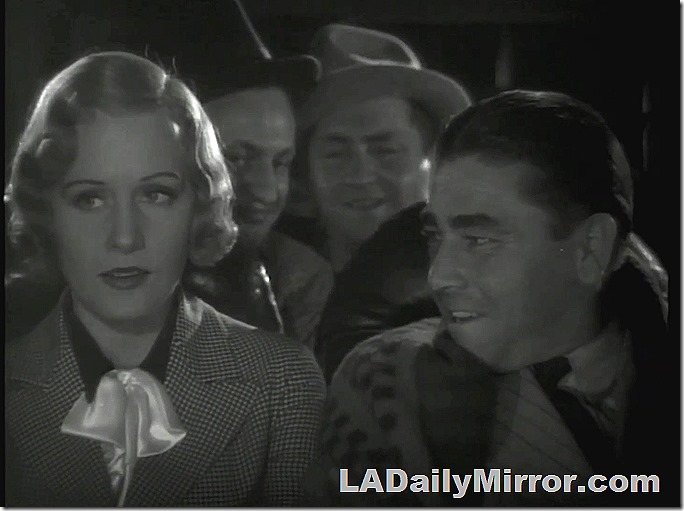 Leading lady, with light hair, checked coat. Sitting next to mystery fellow. 