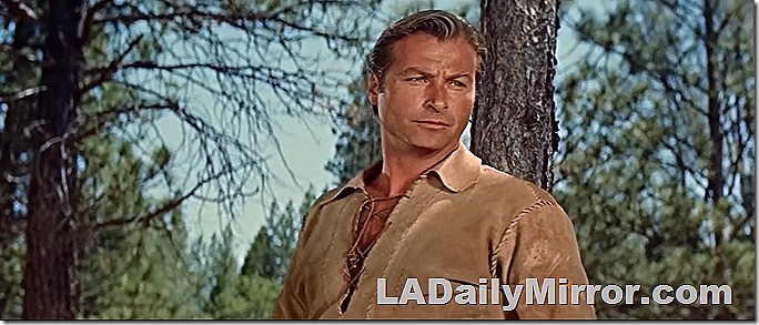 Blond man in frontiersman outfit. He is in the woods. Blond man in frontiersman outfit. He is in the woods.