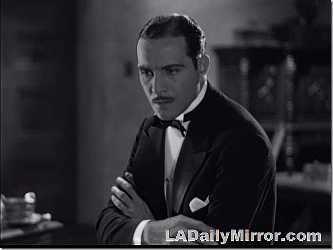 Man in tuxedo, slim mustache, slick hair, looks incredulous.