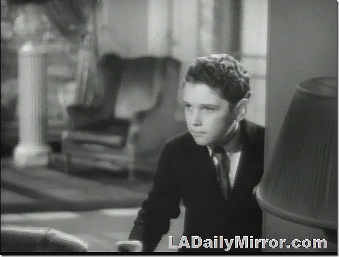 Boy with curly hair. Wearing a coat and tie. He looks concerned and angry Boy with curly hair. Wearing a coat and tie. He looks concerned and angry