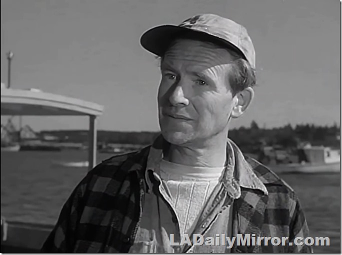 Man in cap. He wears several layers of clothing. 