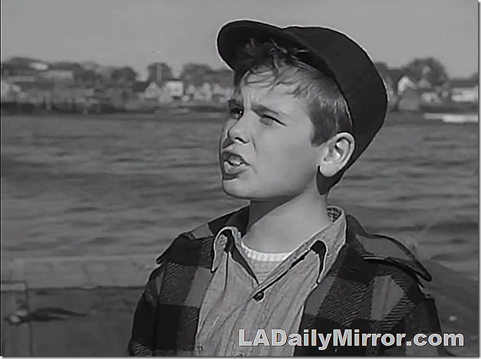 Boy wearing cap. Water in background
