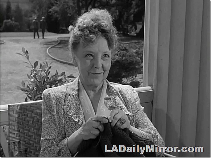 Woman with her hair up. She's knitting. 