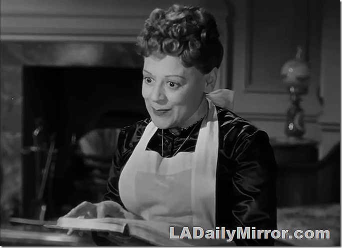 Woman in maid's outfit, reading a book. 