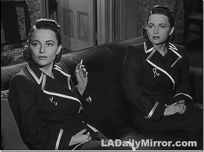 Two women sitting on a couch. They look remarkably siimilar. 