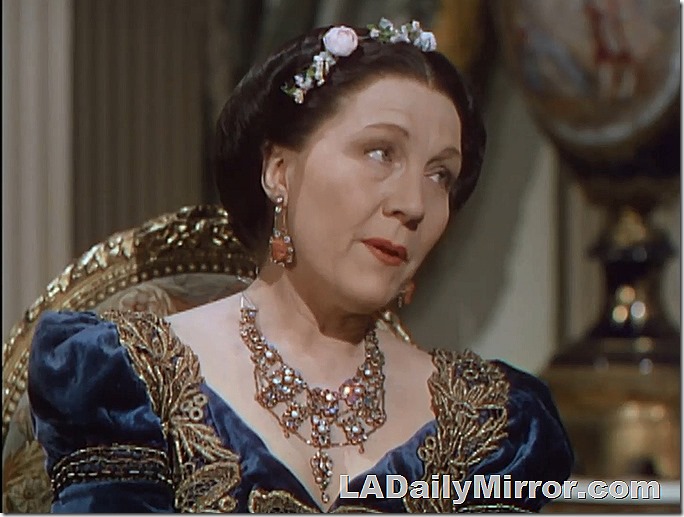 Woman in elaborately embroidered gown, fancy necklace and earrings