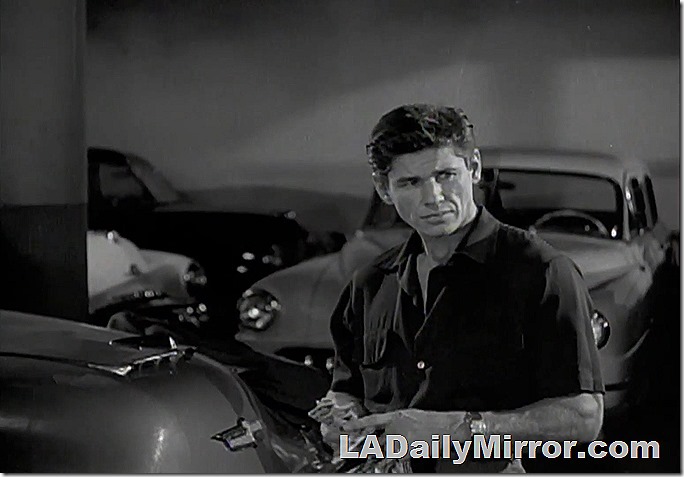 Man stands in the middle of parked cars. Man stands in the middle of parked cars.