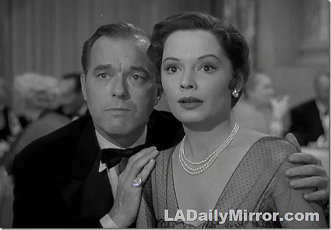 Well-dressed couple. He's in a suitcoat and bow tie. She's wearing an expensive dress, a pearl necklace and earrings. Well-dressed couple. He's in a suitcoat and bow tie. She's wearing an expensive dress, a pearl necklace and earrings.