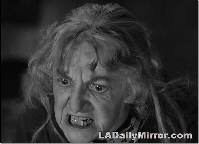 Older woman with disheveled hair, grimacing