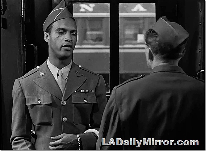 Soldier in Army uniform, and another with his back to the camera. 