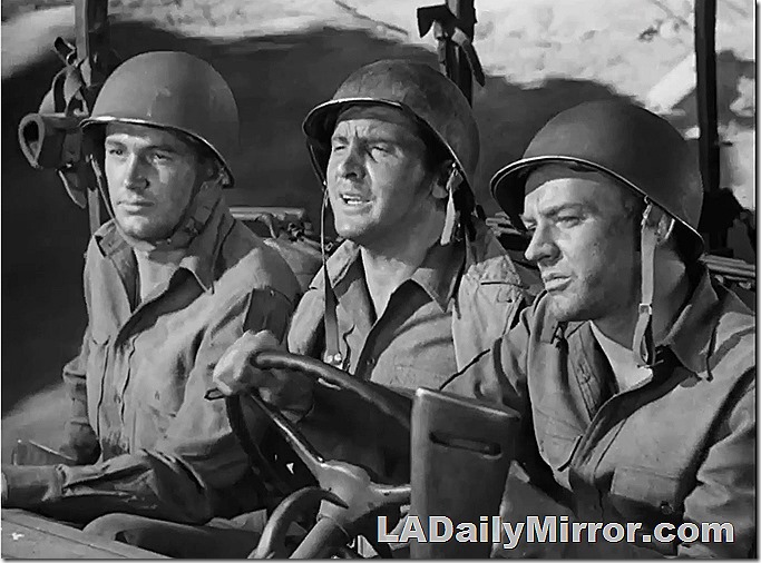 Soldiers in helmets riding in a vehicle