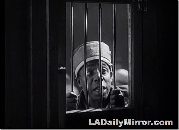 Man looking through metal bars. 