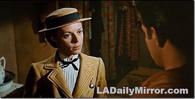 Woman in hat and coat. A small watch is pinned to the coat. Very proper