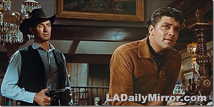 Sheriff (in vest and black hat) listens to dying bad man's final words. 