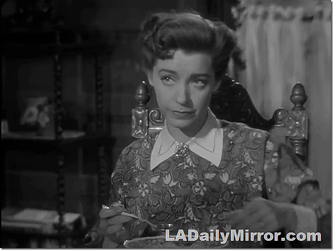 Woman eating soup. She's wearing a patterned dress, light-colored collar and a bit of jewelry at her throat. Woman eating soup. She's wearing a patterned dress, light-colored collar and a bit of jewelry at her throat.