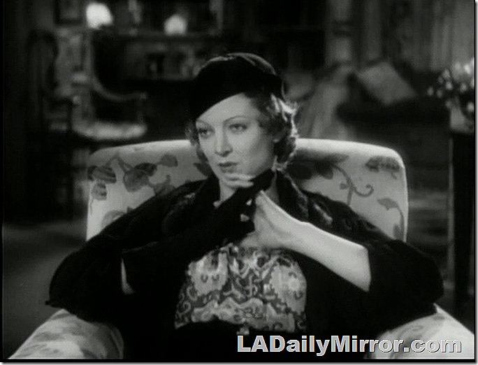 Woman in armchair. She's wearing a beret and very fashionable. 