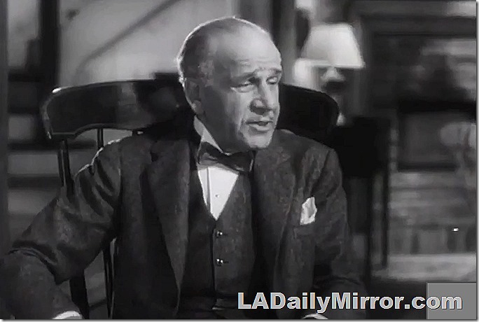 Older man in coat and vest, with bow tie and wing collar and pocket scarf.