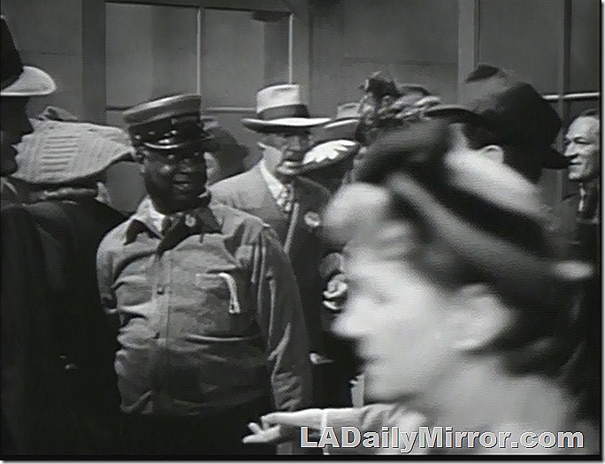 Man in cap, surrounded by people 