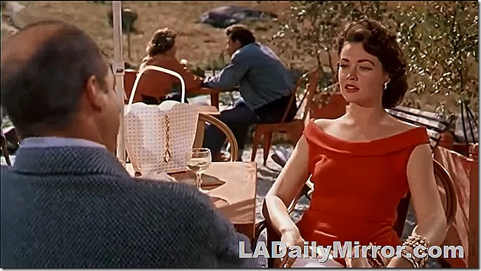 Elegant woman sitting at a table with Back of the Head Guy
