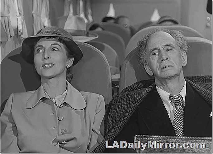 Man on airplane who looks unwell. His seatmate is oblivious. Man on airplane who looks unwell. His seatmate is oblivious.