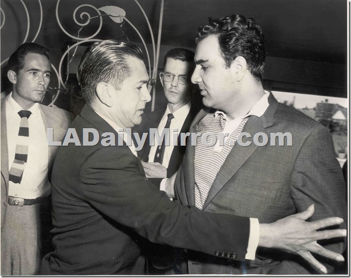 Man in suit vs. man in polo shirt and sport coat. Two men watch with some alarm. 