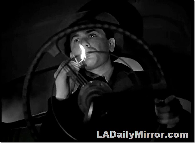 Man driving car, lighting a cigarette, photographed from the floor of the car shooting up through the steering wheel. 