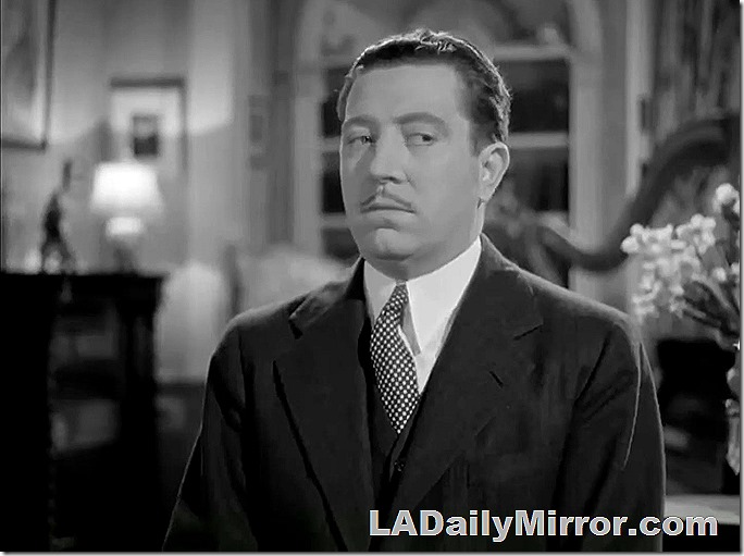 Man in coat and tie, with slight mustache giving the side-eye. 