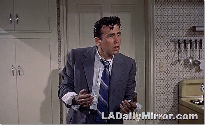 Man in suit coat, tie pulled loose, cuffs rolled up, hands dirty. 