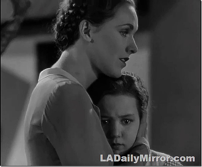 Woman holding girl to her chest. 