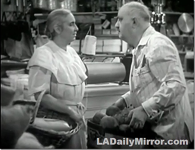Man and woman in store. Man is holding a basket of something heavy. 