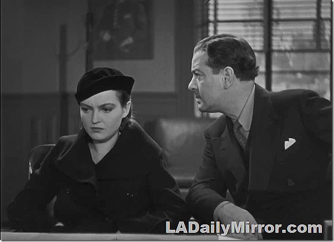 Woman in coat and hat. Man in double breasted suit. 