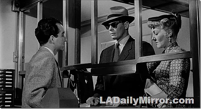 Man in sunglasses and hat, accompanied by mystery woman 