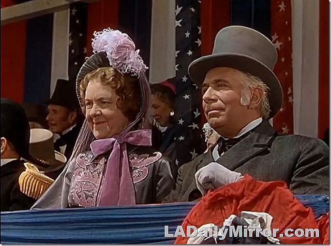 Woman in bonnet and fancy dress. Man in stovepipe hat