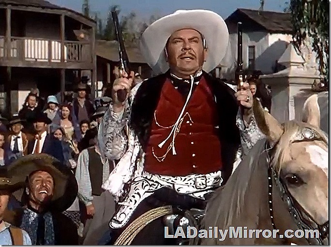 Man in fancy outfit, on horse (also in fancy outfit) with two six-guns