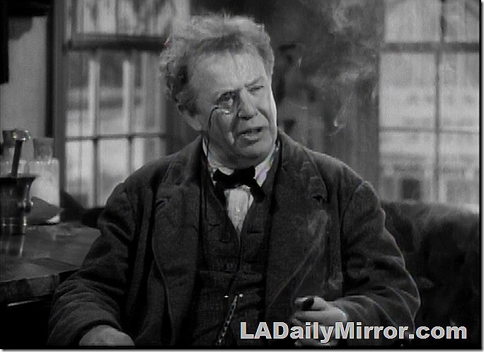 Man in three-piece suit, wearing a monocle. 