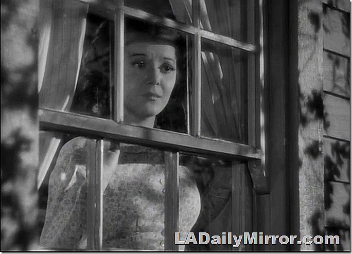 Woman in period costume looking out the window